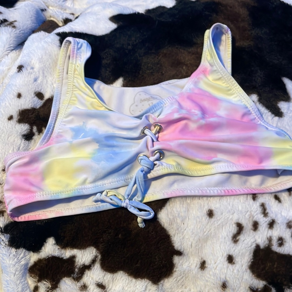 a multi color bathing suit top with cross up the front